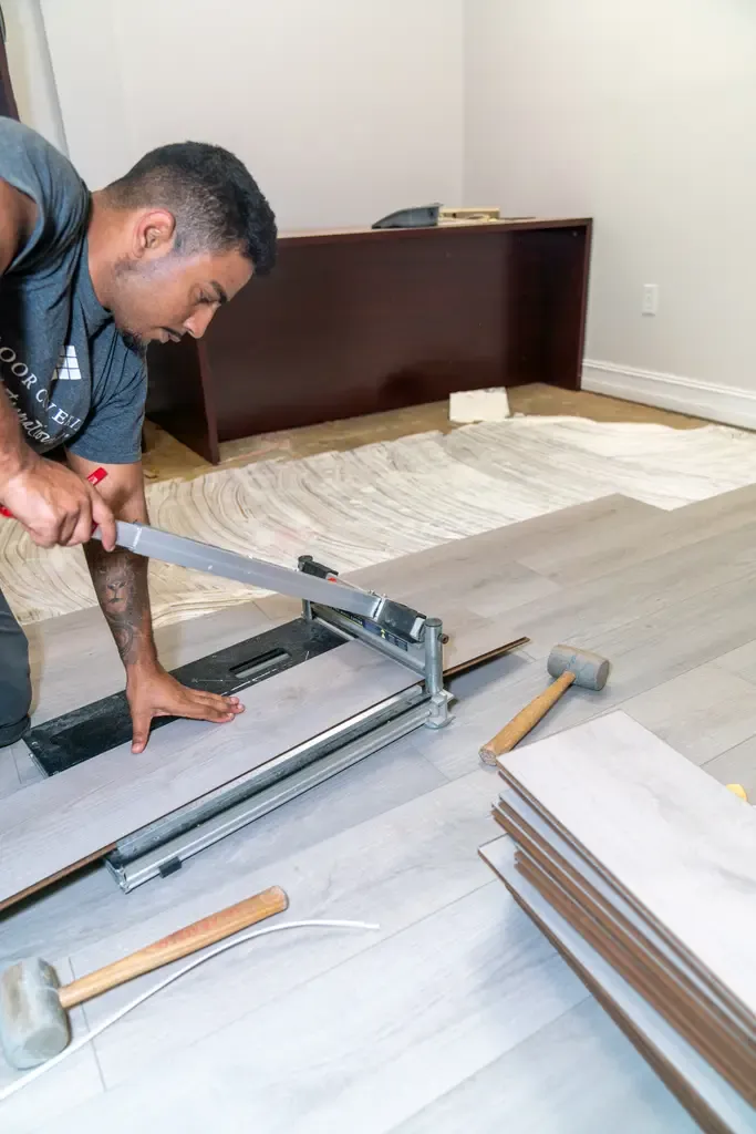 A man is cutting laminate flooring with a saw in Wellington, FL