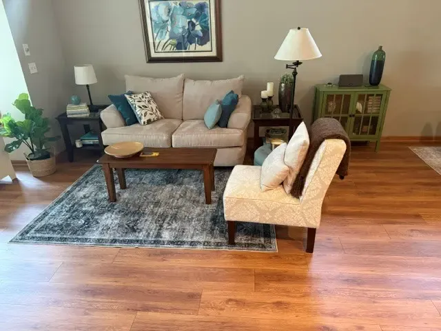 A stylish living room with hardwood flooring and a plush couch, designed for relaxation and comfort in Chanhassen.