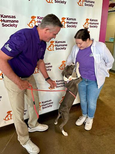 two people and dog jumping up