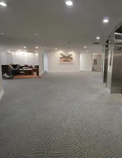 A vacant office space with commercial carpeting and a spacious elevator, located in Jupiter, FL.
