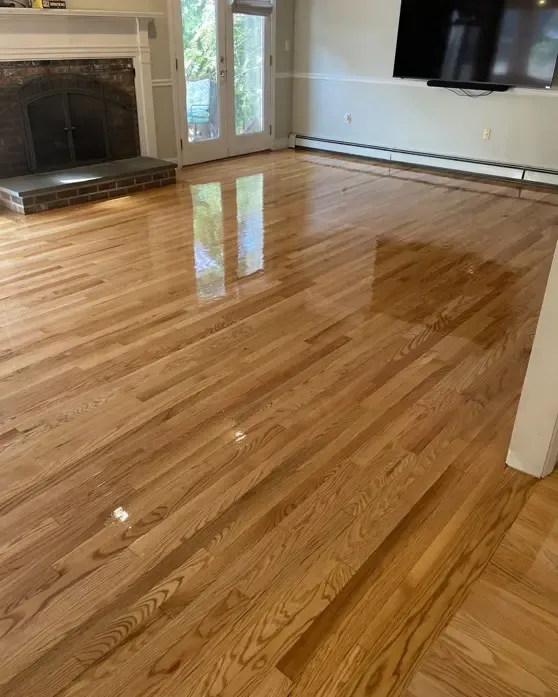 A hardwood floor complements a fireplace in a living room setting, highlighting Foxboro, MA wood flooring.