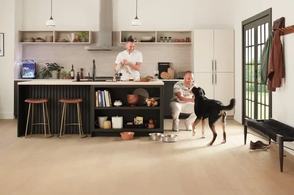Family in kitchen playing with dog