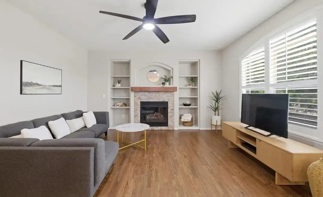 A living room featuring a ceiling fan and a couch, showcasing fresh flooring in Aurora, CO.